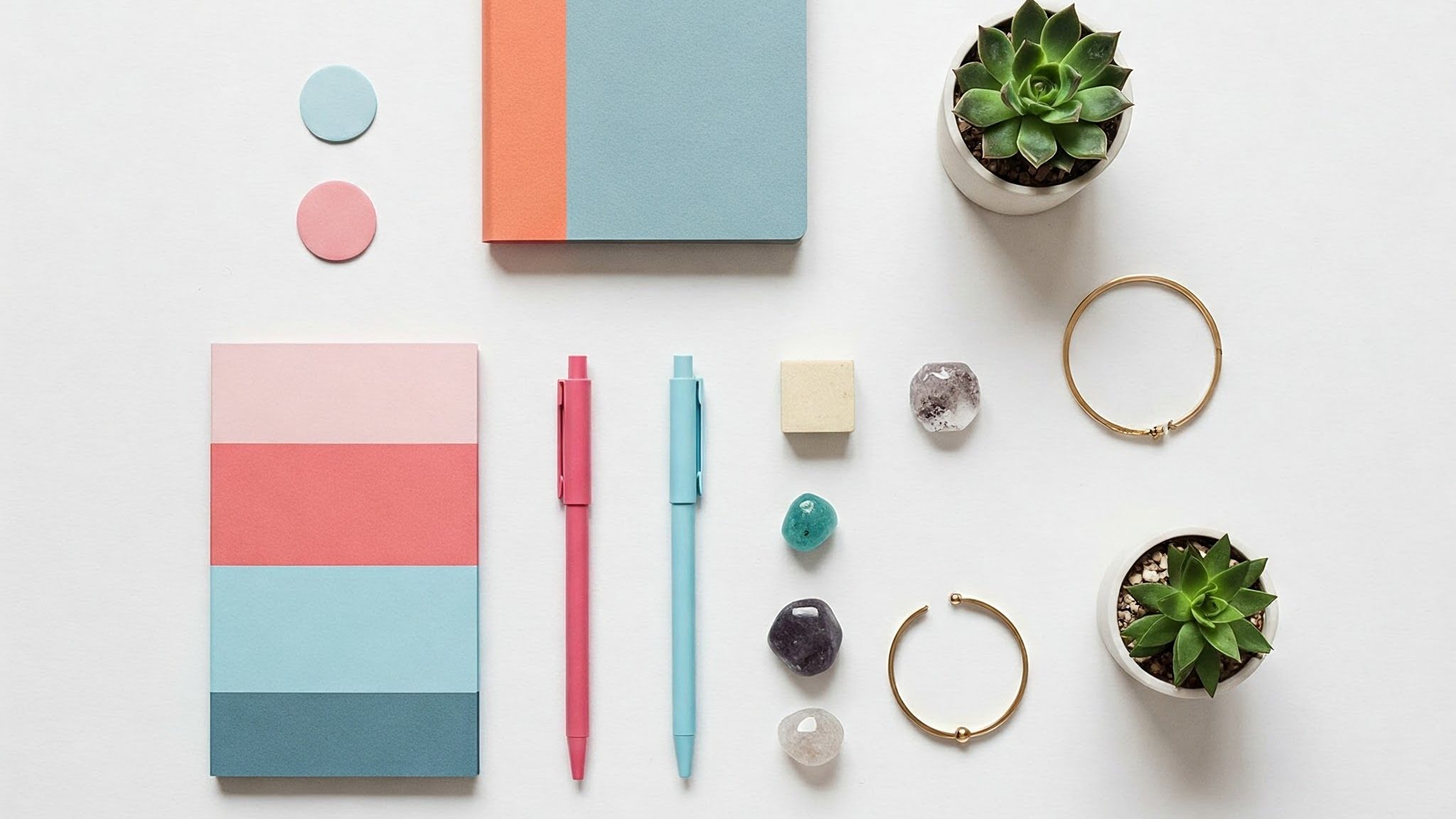 Creating Engaging Social Media Content A minimalist flat lay featuring an assortment of small, colorful, and aesthetically pleasing items artfully arranged on a pristine white background.