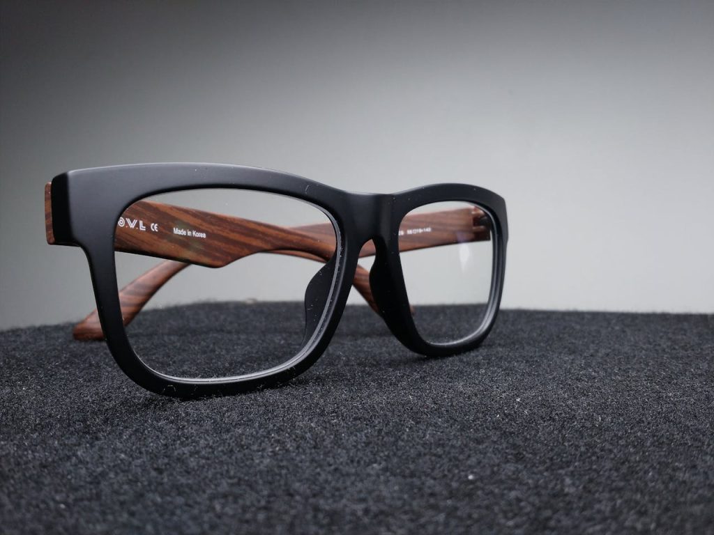 Capturing High-Quality Product Photos Close-up of black-framed eyeglasses placed on a dark, textured background.