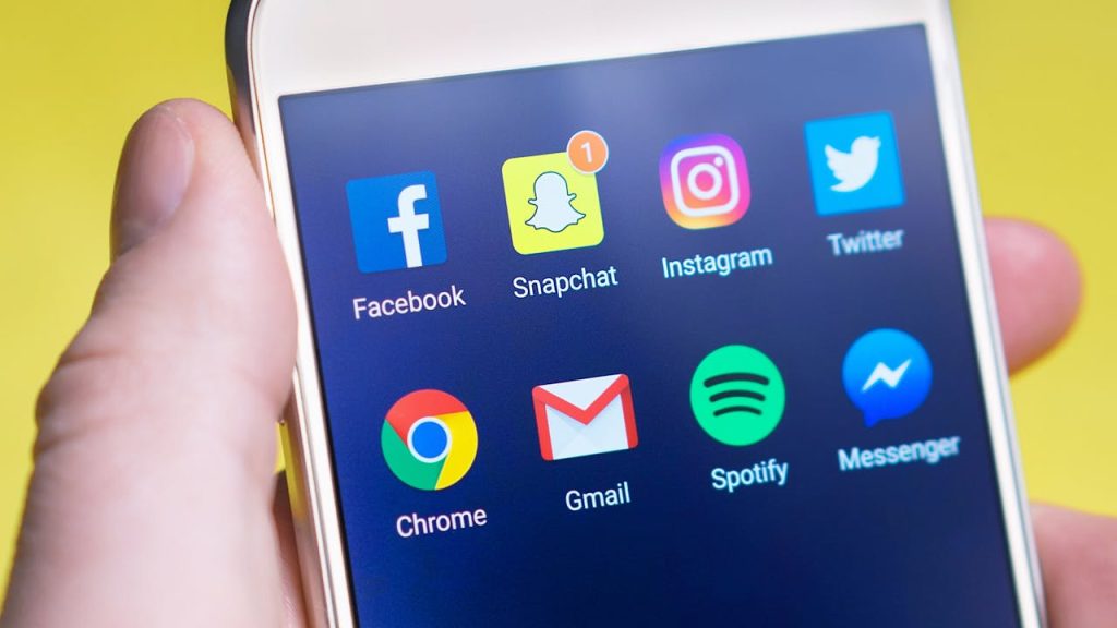 Leveraging Social Media for Promotion Close-up of a smartphone screen showcasing an open app folder filled with social media icons.